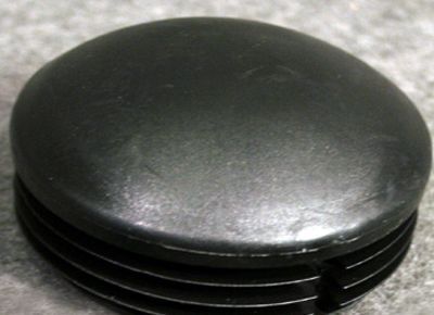 Un primer plano de una gorra de plástico negra sobre una alfombra.