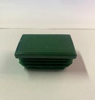 Una tapa de plástico verde se encuentra encima de una mesa blanca.