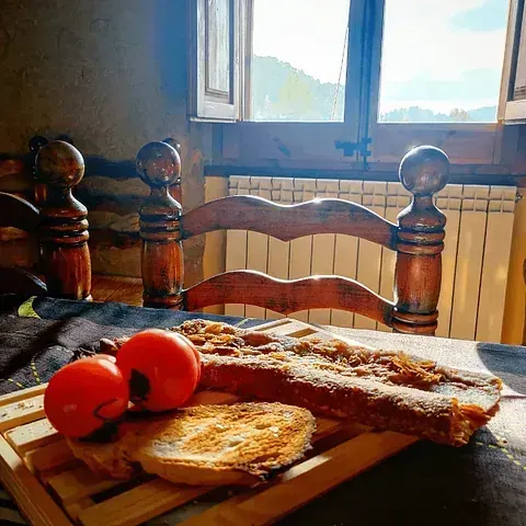 Una mesa de madera con una bandeja de comida y tomates encima.