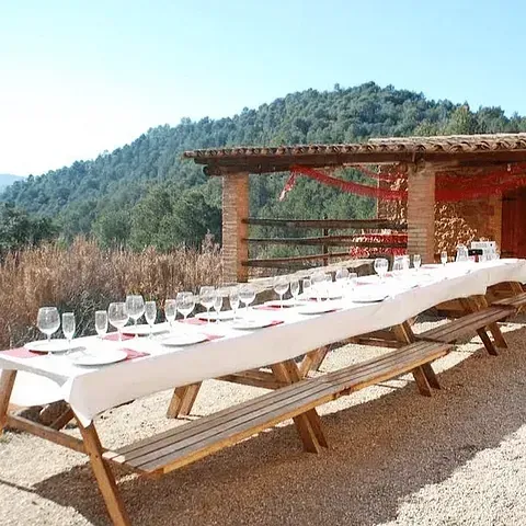 Una mesa larga con platos y copas de vino encima.