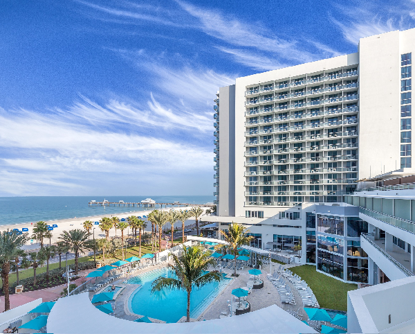An aerial view of a large swimming pool surrounded by palm trees