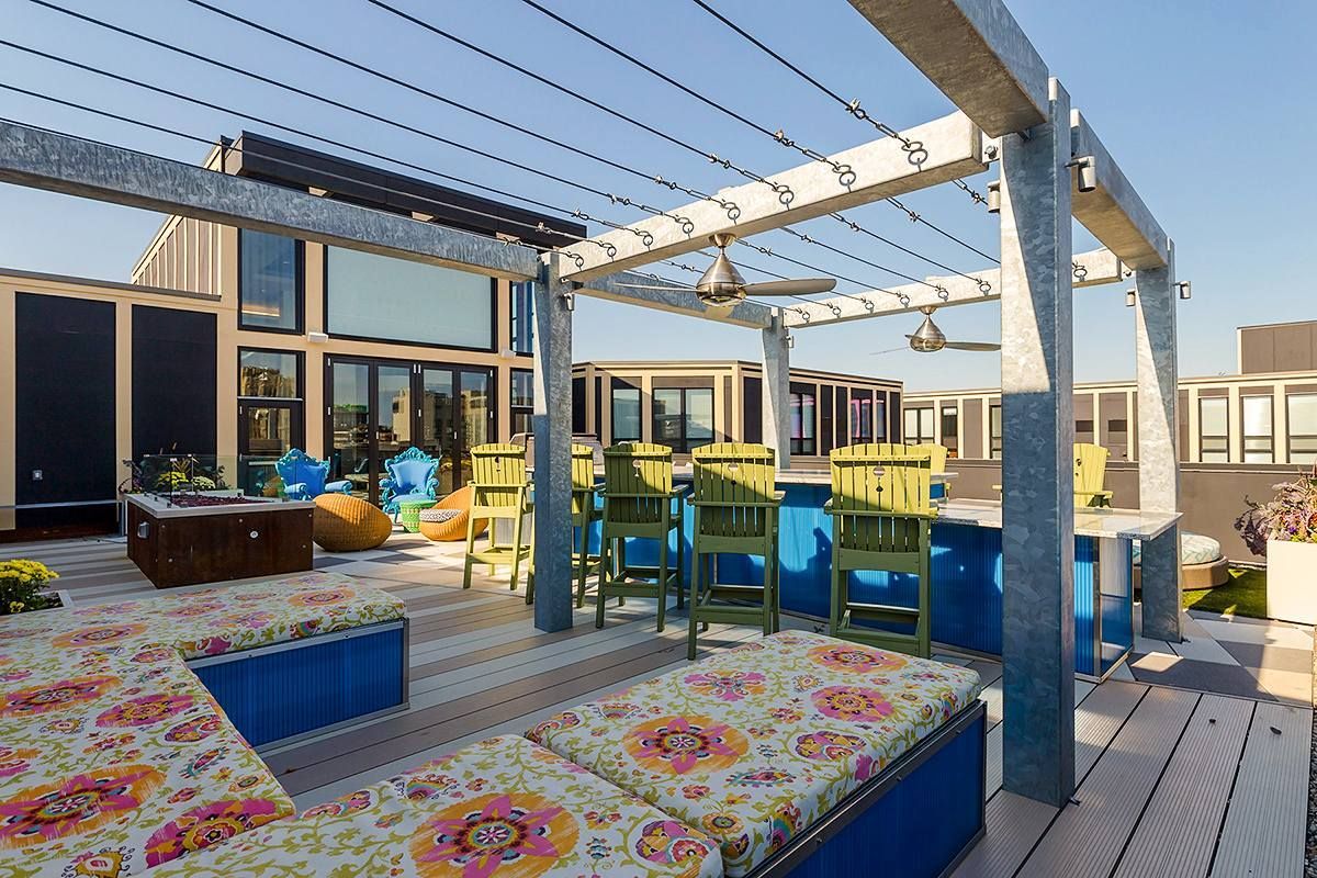 A rooftop deck with a pergola and a bar