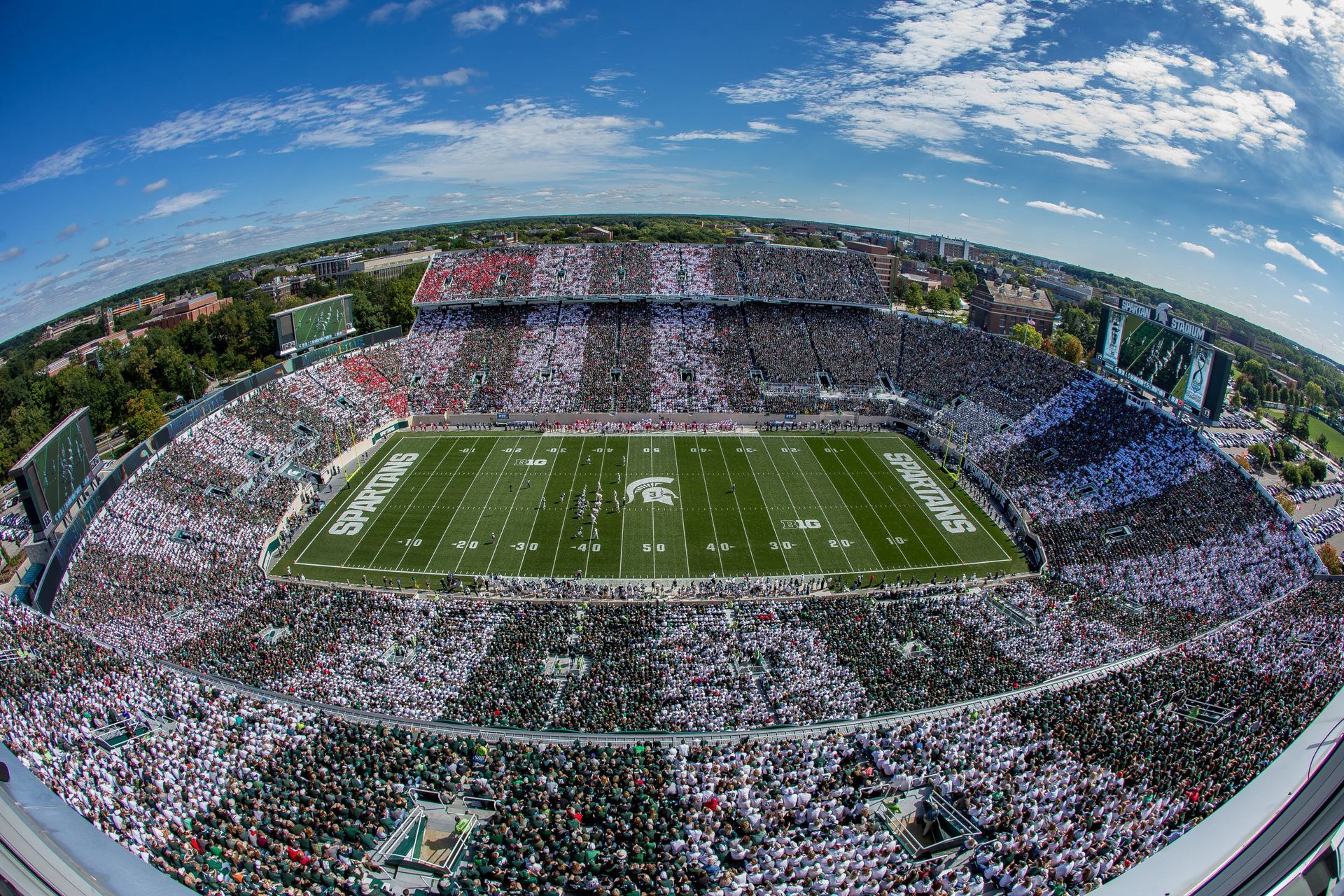 An aerial view of a football stadium filled with people watching a game.