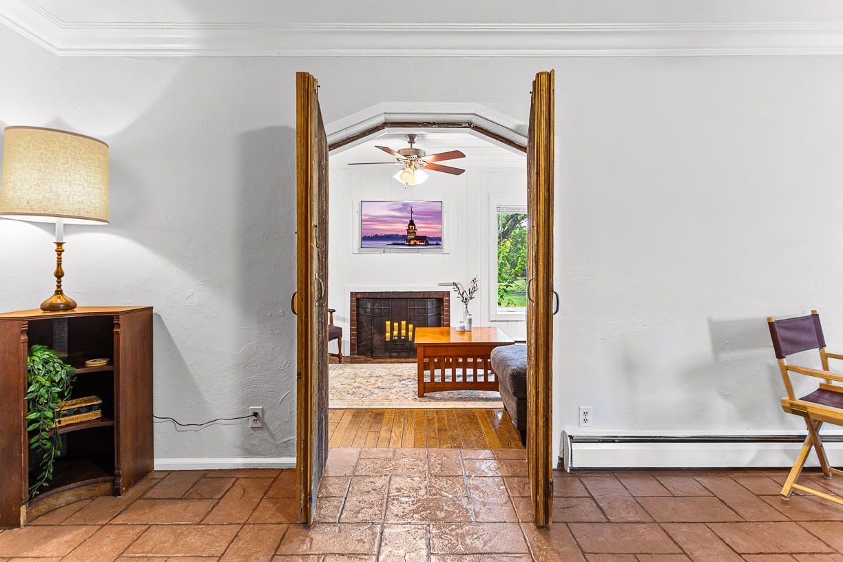 A living room with a ceiling fan and a fireplace.
