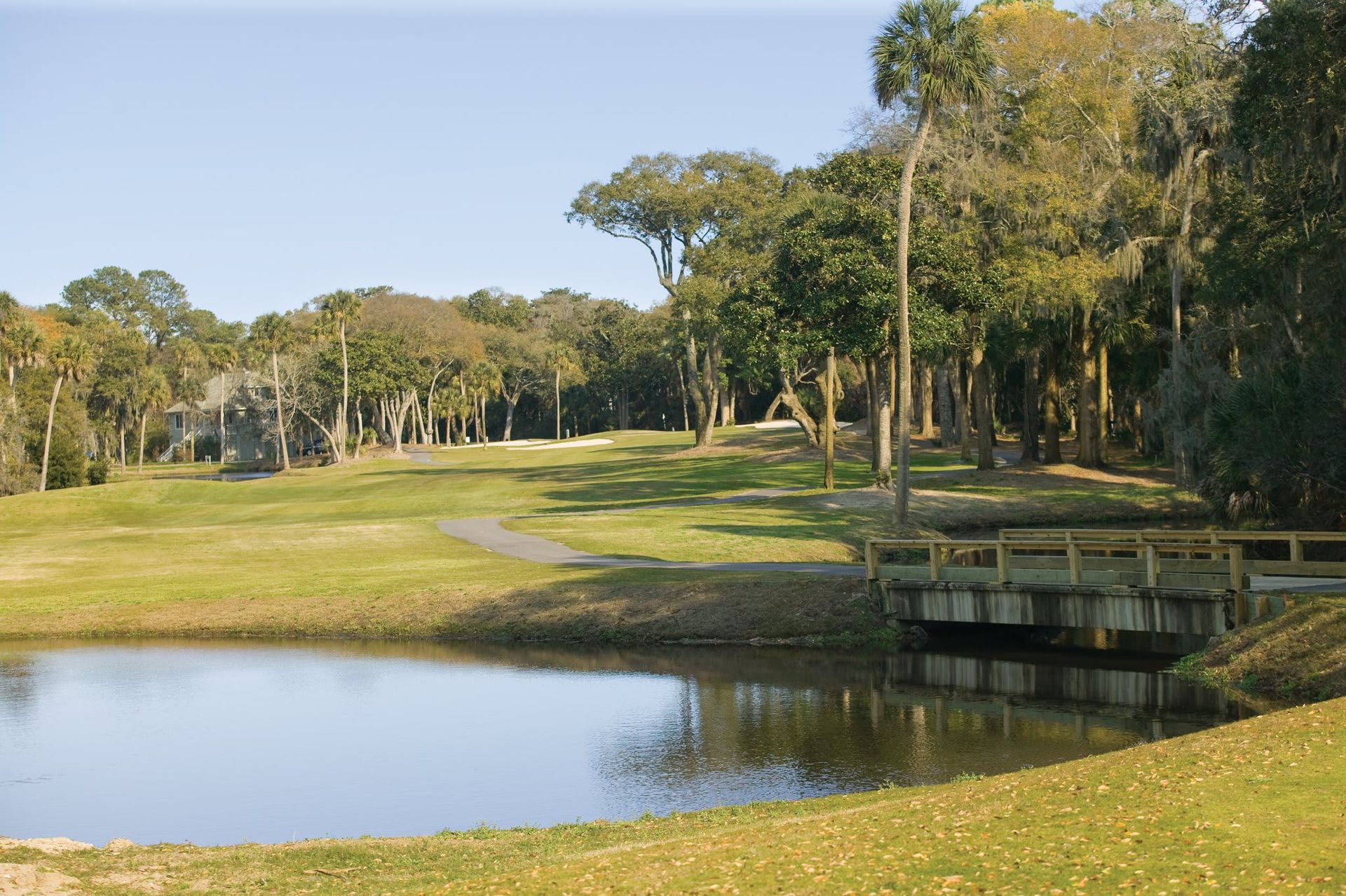 A golf course with a bridge over a pond