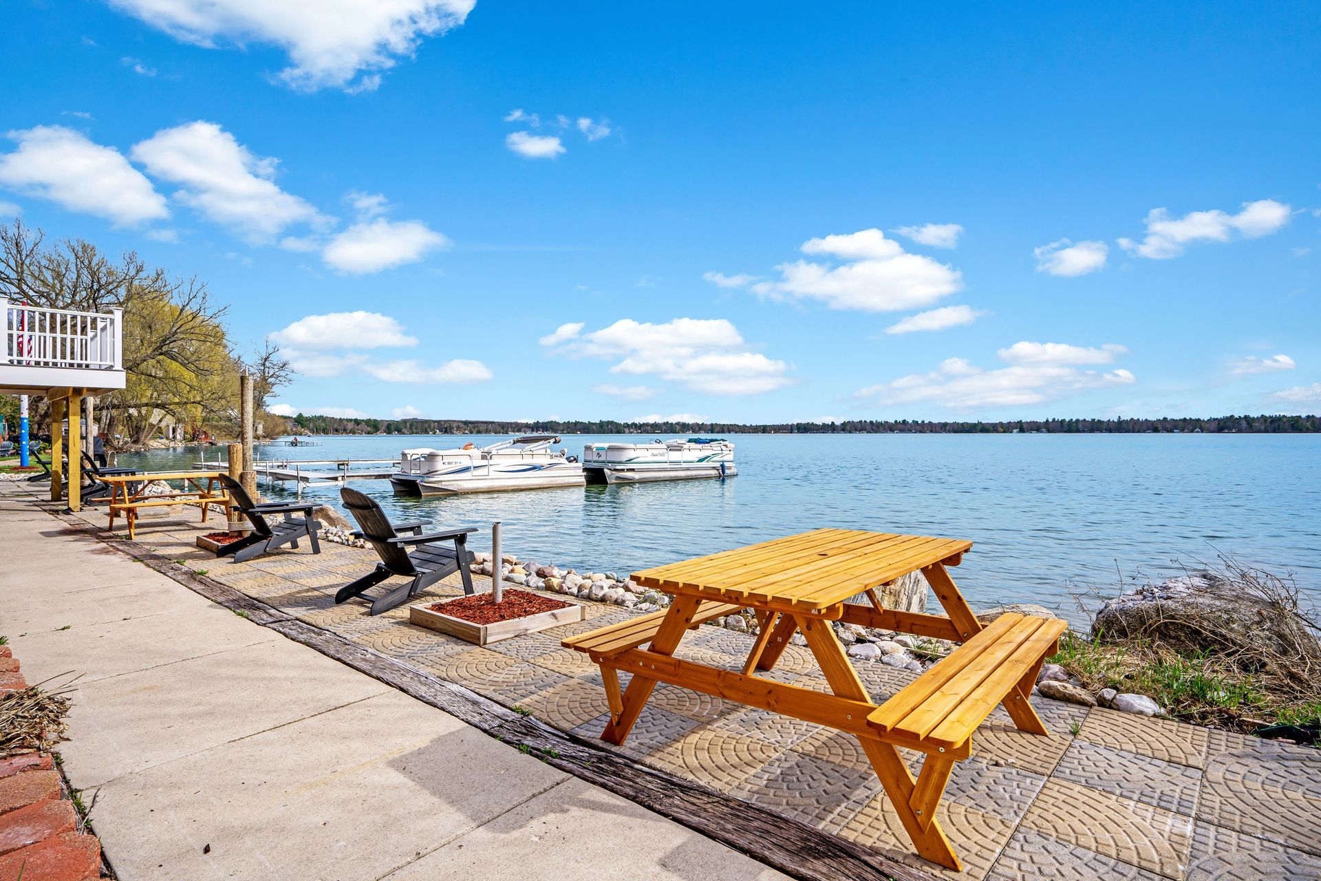 A yellow picnic table is sitting on the shore of a lake.