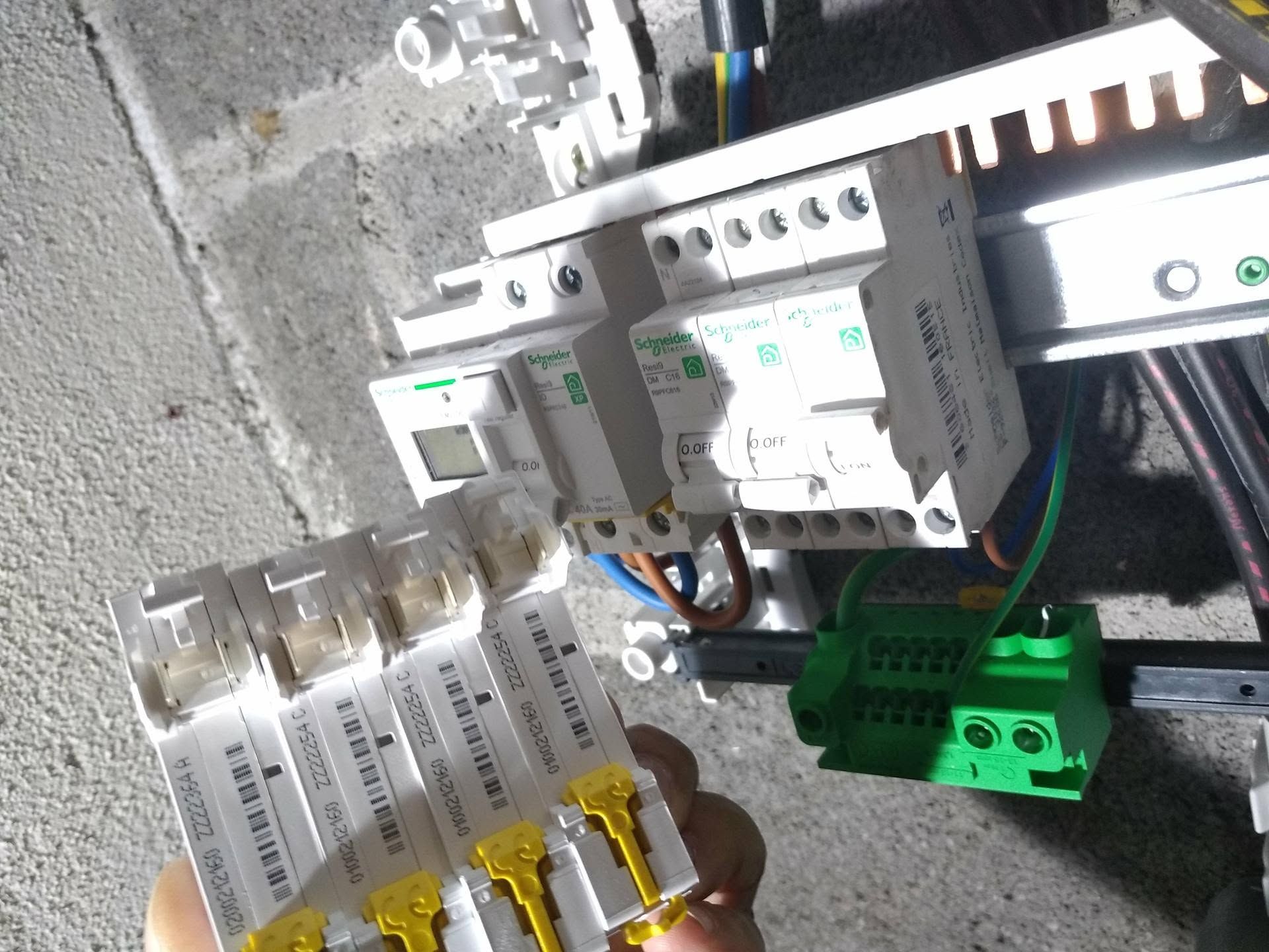 Tableau électrique avec disjoncteurs, câblage et bornes dans un boîtier.