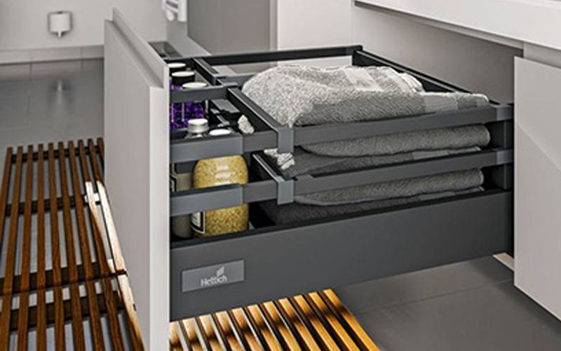 Un cajón de baño lleno de toallas y botellas.