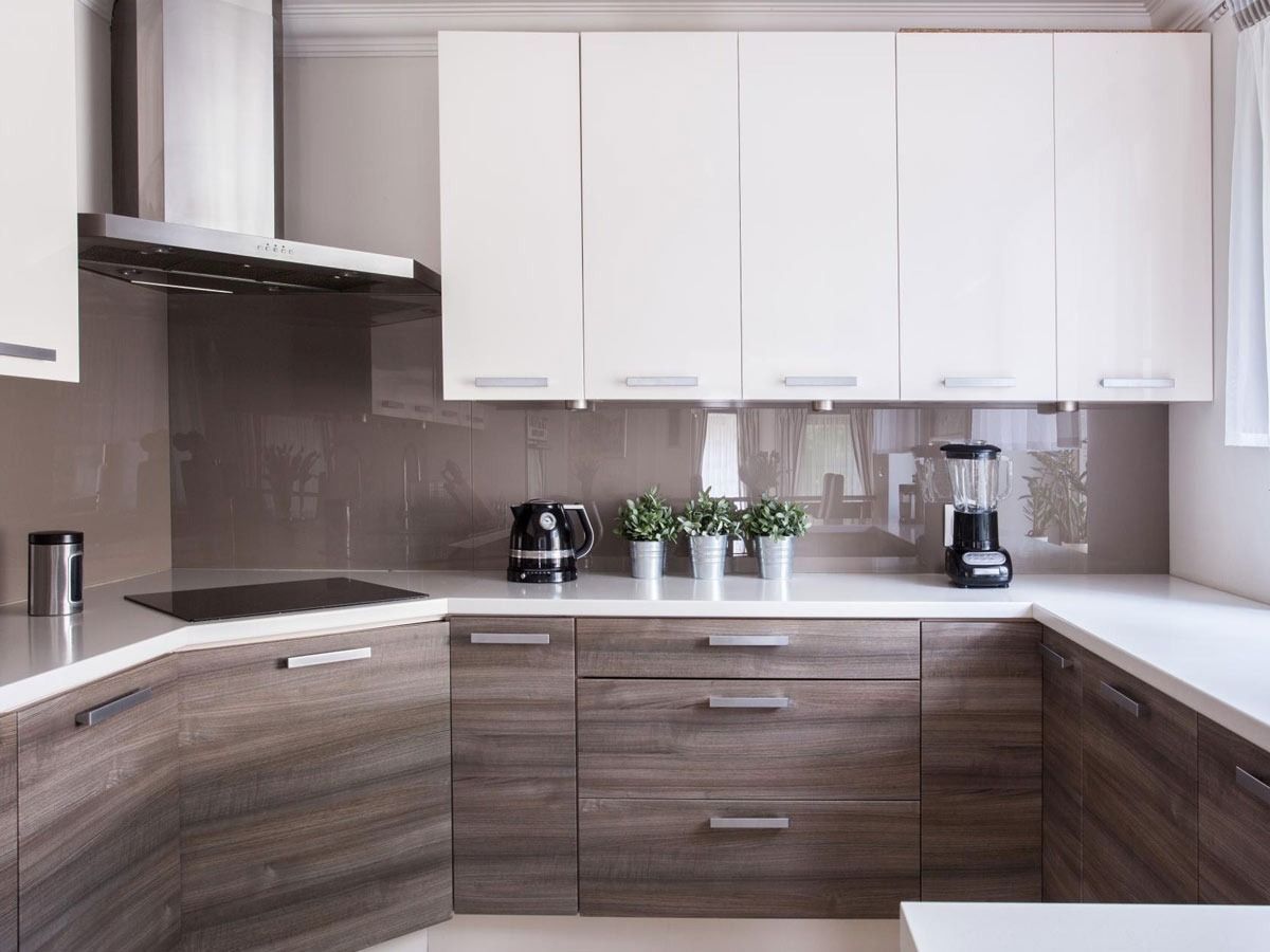 Una cocina con gabinetes de madera y encimeras blancas.