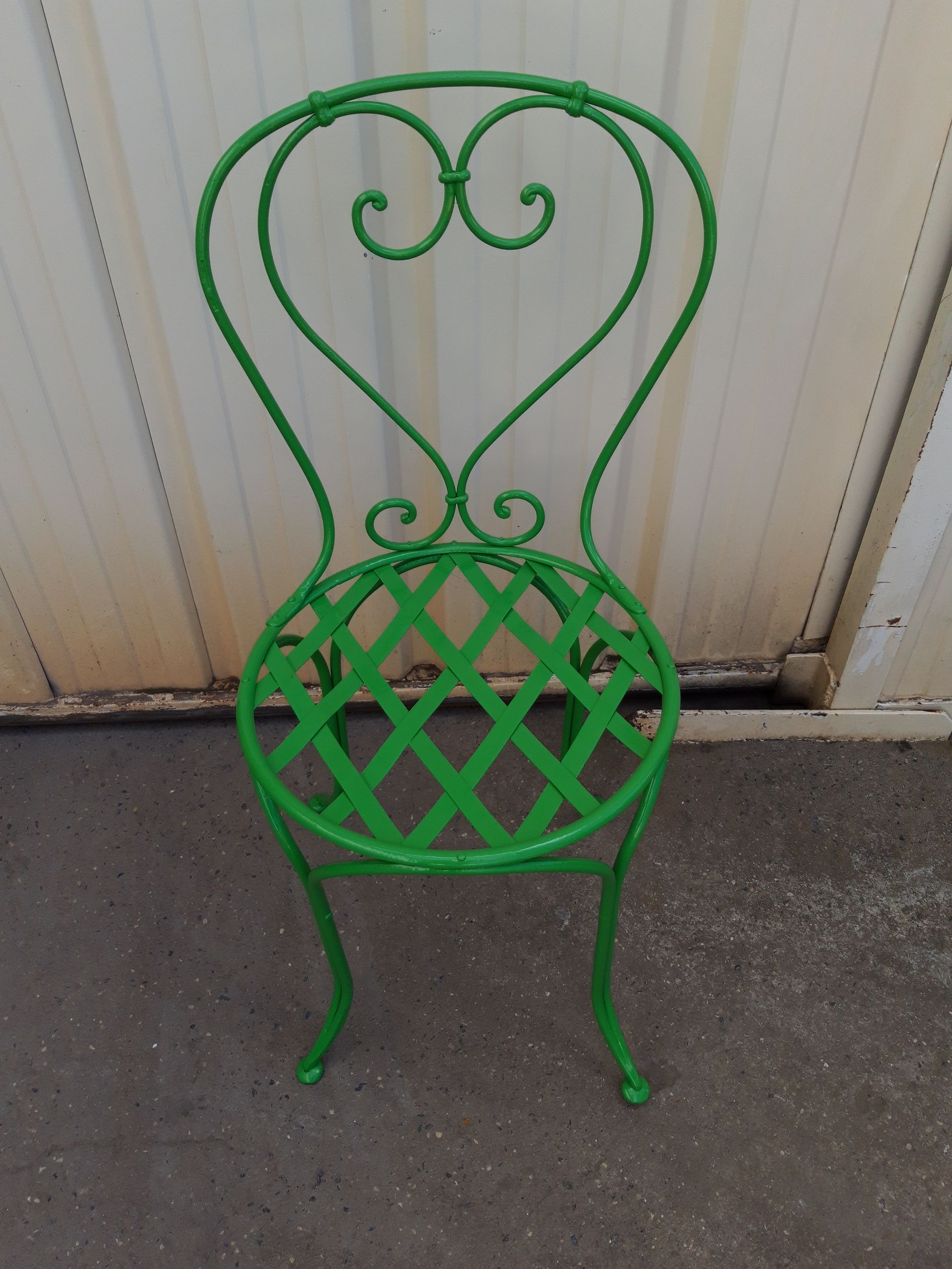 Chaise de jardin verte en métal qui a bénéficié d'un décapage par bain.