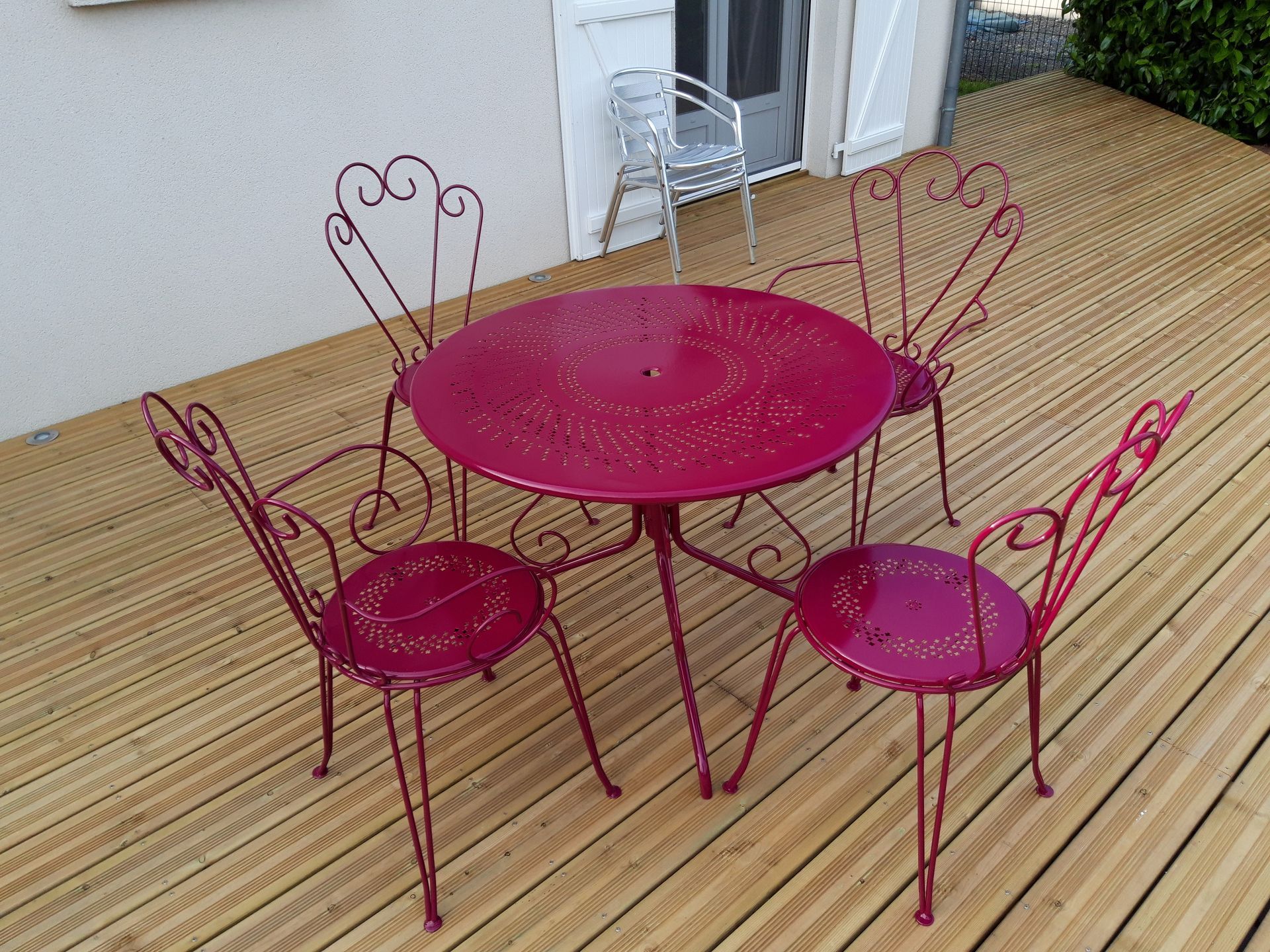Ensemble de table et chaises de jardin en métal avec peinture bordeaux après décapage