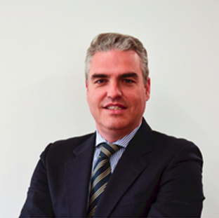 Um homem de terno e gravata está sorrindo para a câmera