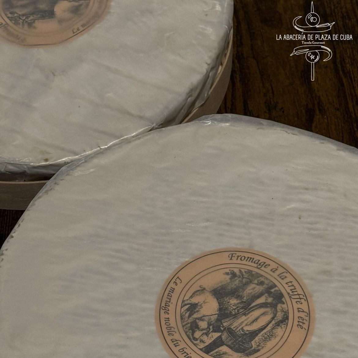 Dos quesos redondos con corteza blanca, uno de ellos con una etiqueta que dice 