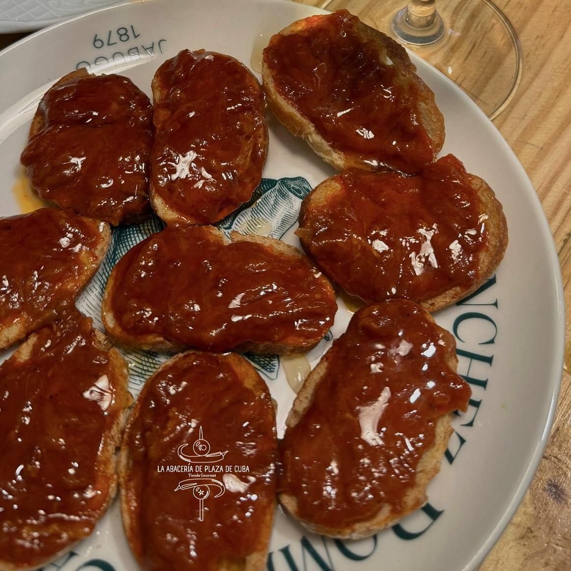 Rebanadas de pan tostado cubiertas con una masa oscura y brillante dispuestas en un plato.