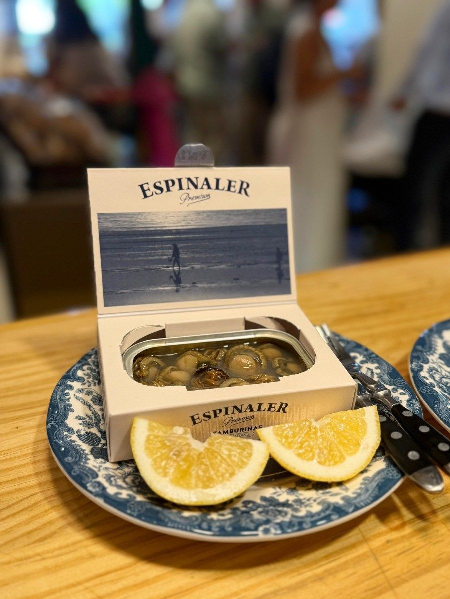 Conservas de marisco de Espinaler en plato azul y blanco con rodajas de limón.