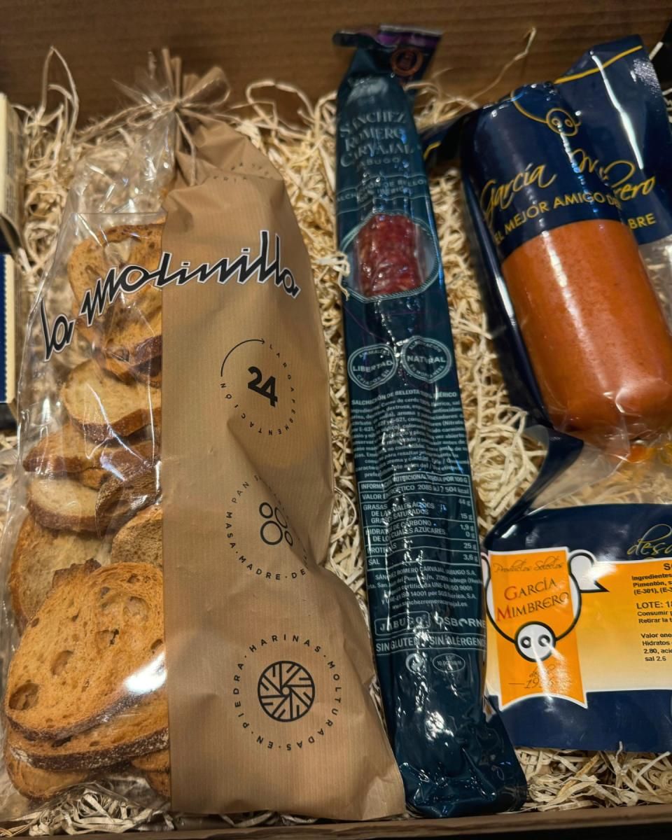 Cesta de regalo de charcutería con galletas, salchichas y otros productos envasados.