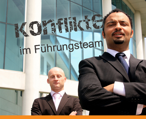 Zwei Männer in Anzügen stehen vor einem Gebäude mit der Aufschrift „Konflikte im Führungsteam“.