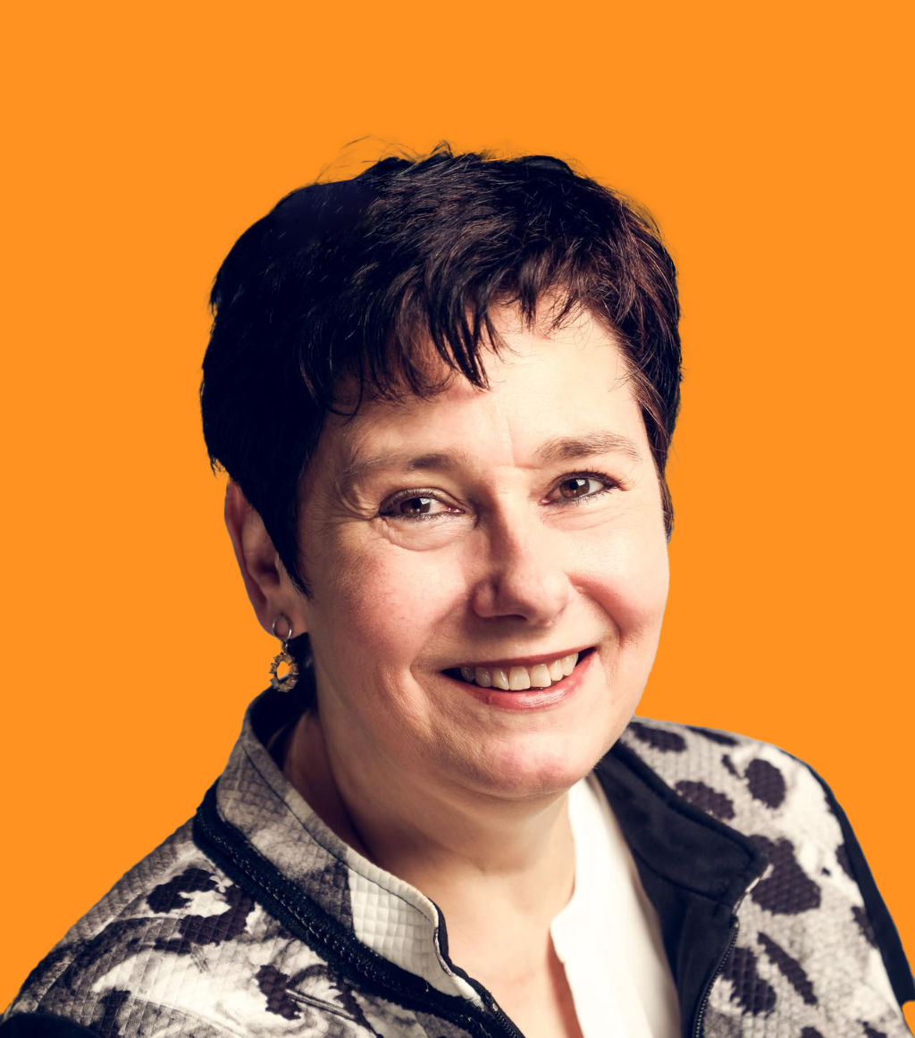 Eine Frau lächelt und trägt eine Jacke mit Leopardenmuster