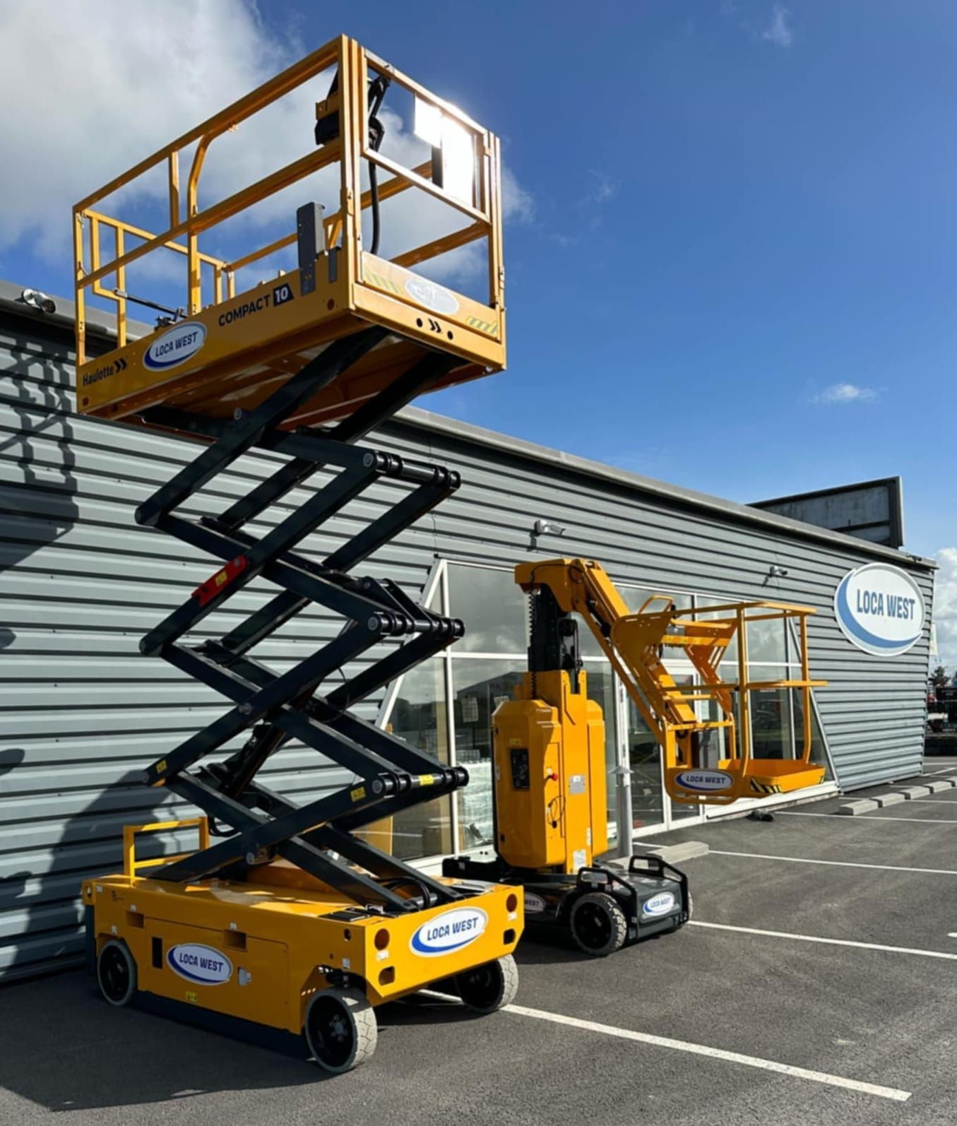 Une nacelle élévatrice à ciseaux jaune à côté d'une nacelle élévatrice à flèche jaune