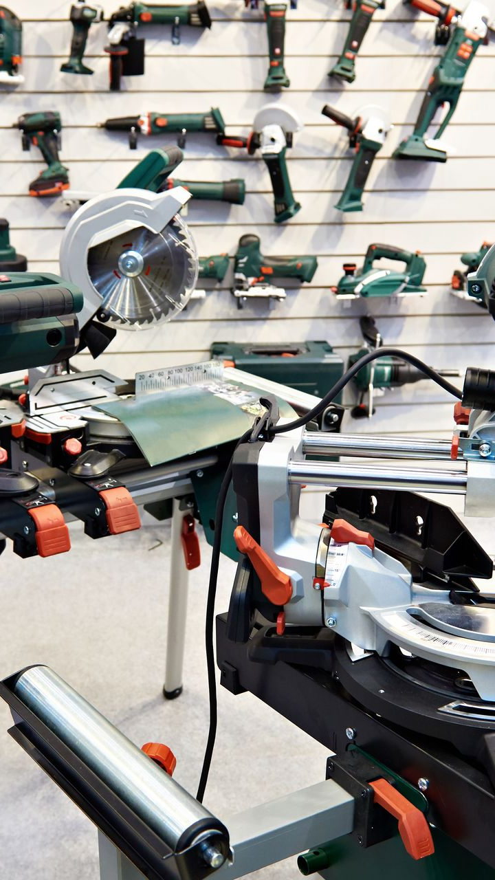 Une vitrine présentant divers outils électriques, dont une scie à onglets 