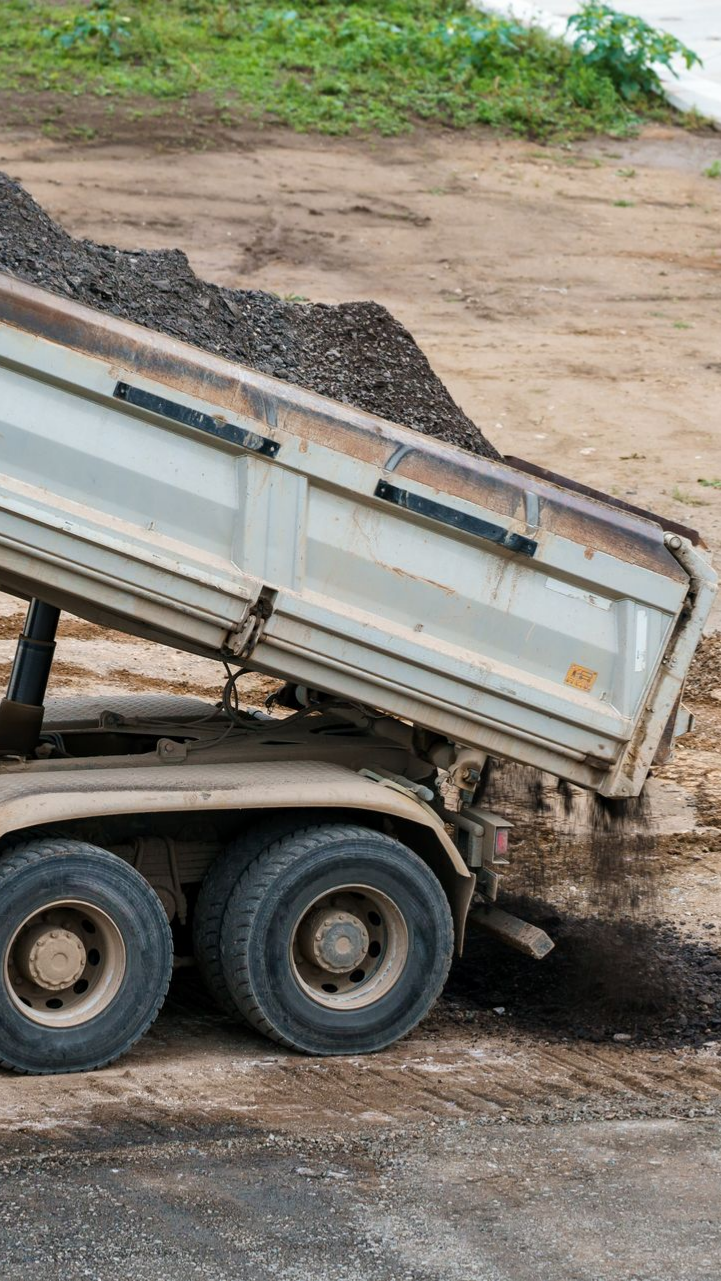 Un camion-benne déverse une cargaison d'asphalte 