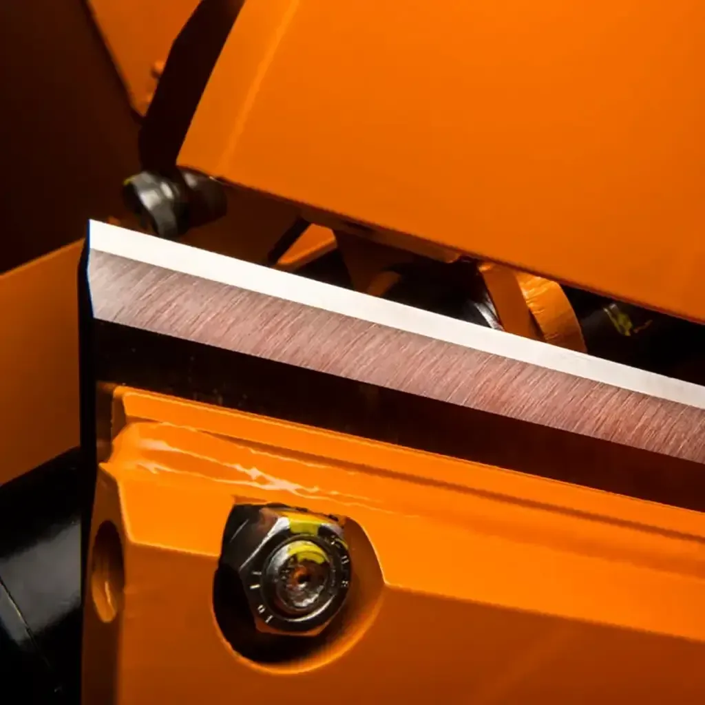 Gros plan sur une pièce mécanique orange avec une lame