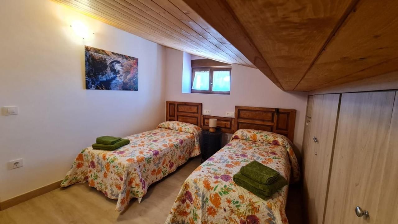 Un dormitorio con dos camas y un cuadro en la pared.