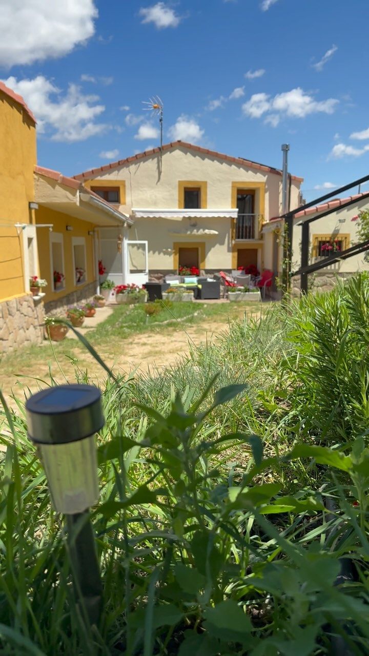 Hay una casa al fondo y una lámpara en primer plano.