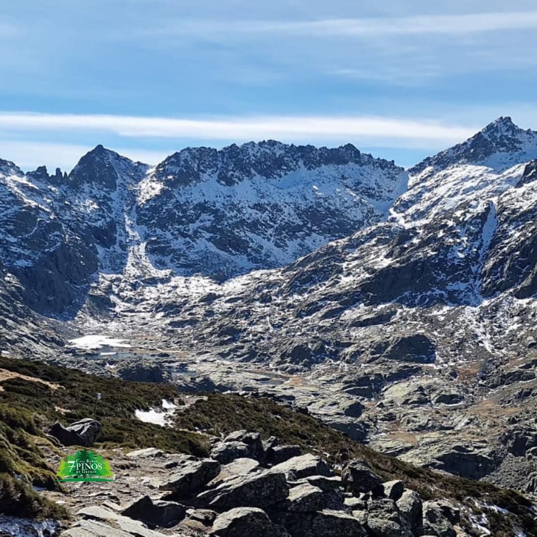 Una montaña cubierta de nieve y rocas con un cielo azul de fondo.