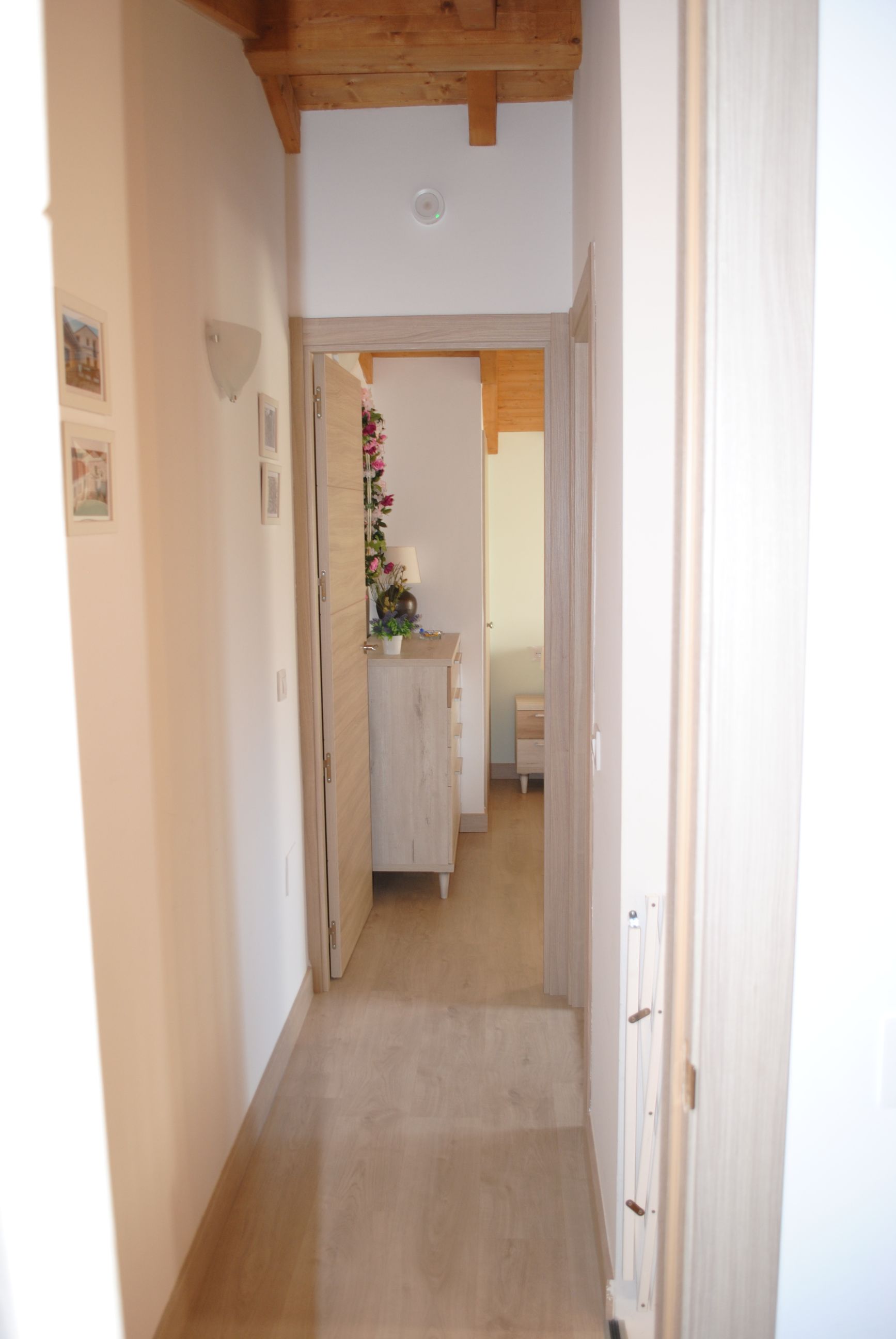 Un pasillo que conduce a un dormitorio con techo de madera.