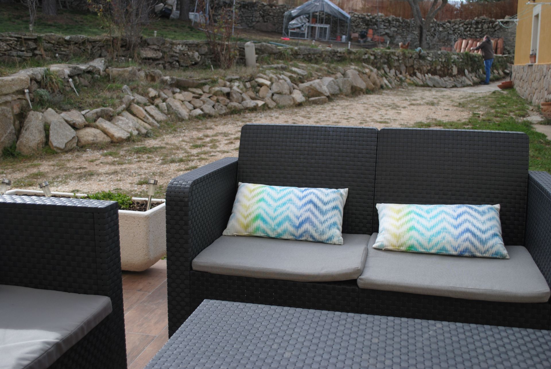 Un patio con un sofá y una mesa con almohadas.