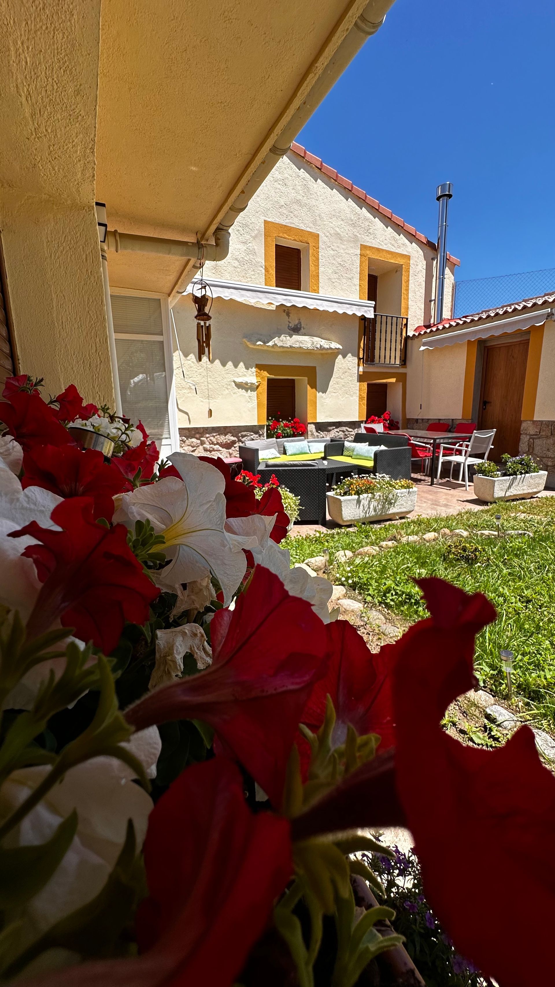 Una casa con flores rojas y blancas en el frente.