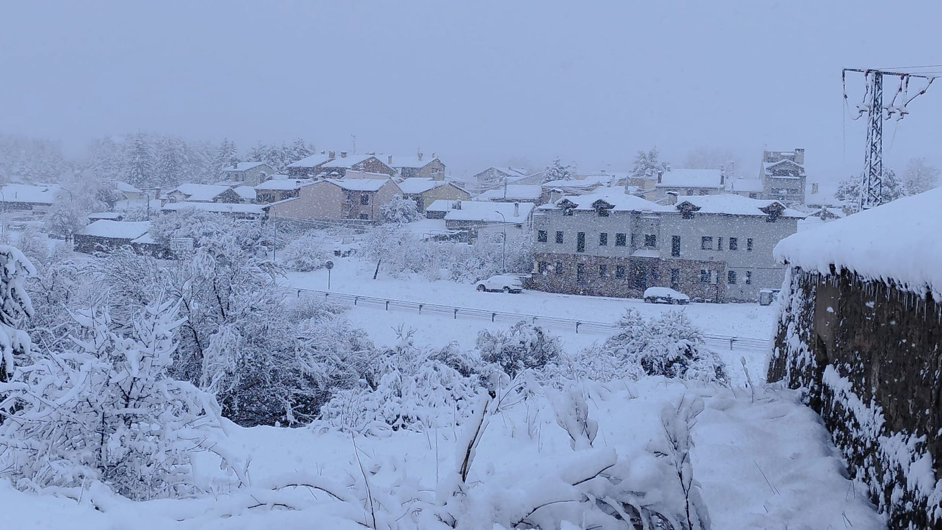 Un paisaje nevado con edificios y árboles cubiertos de nieve.