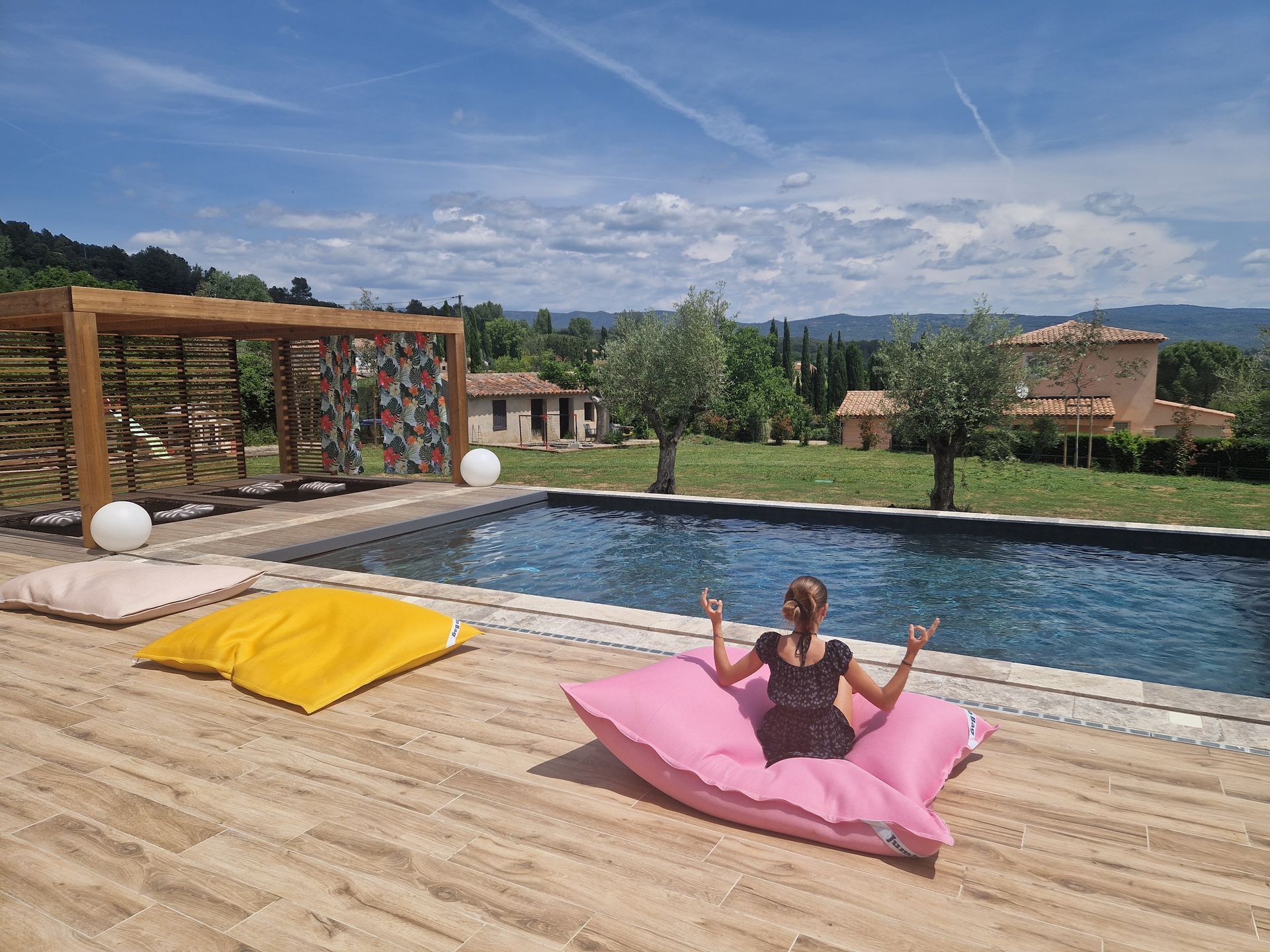 Photo d'une personne faisant du yoga devant une piscine