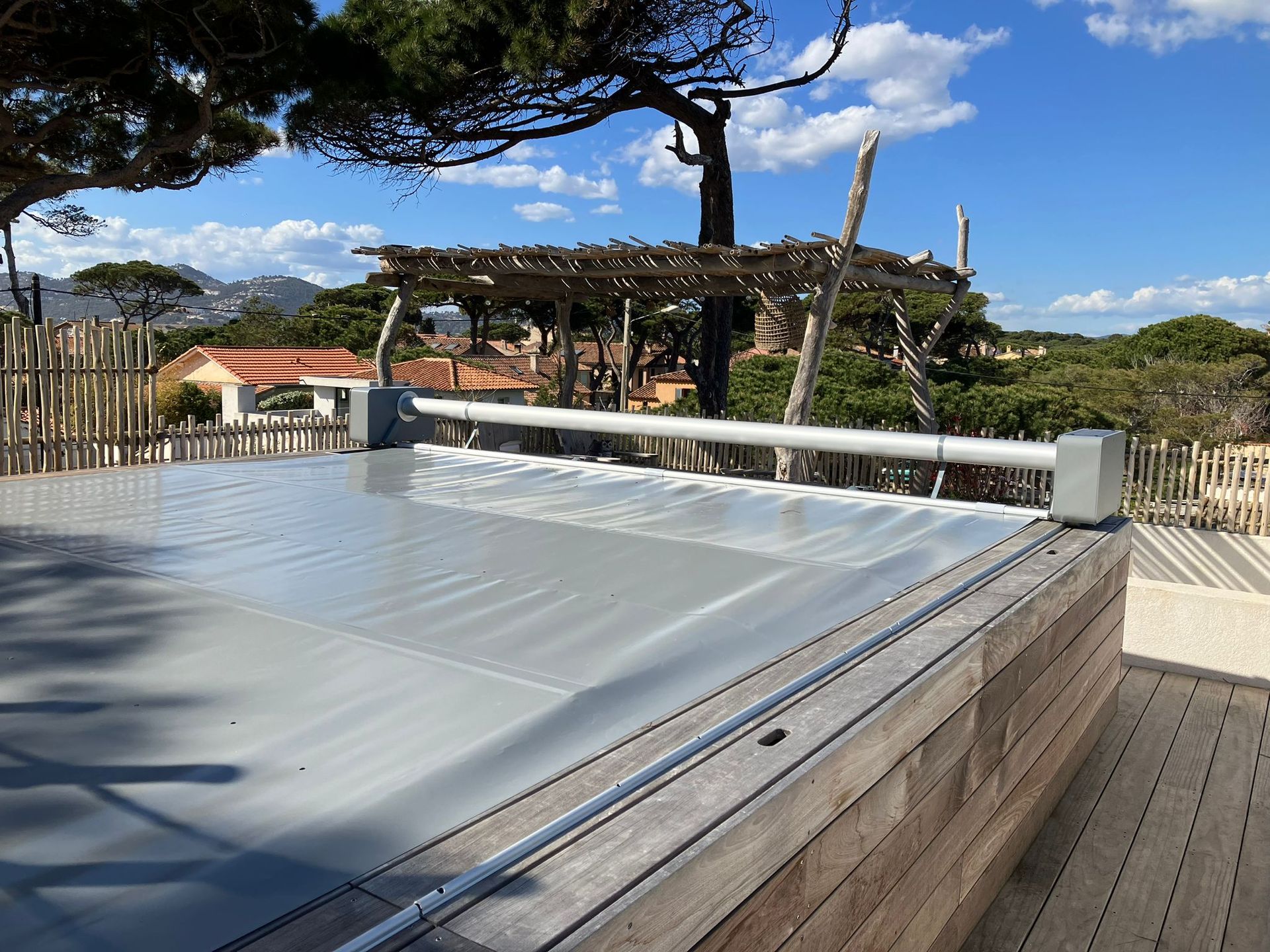 Photo d'une bâche grise déroulée sur une piscine