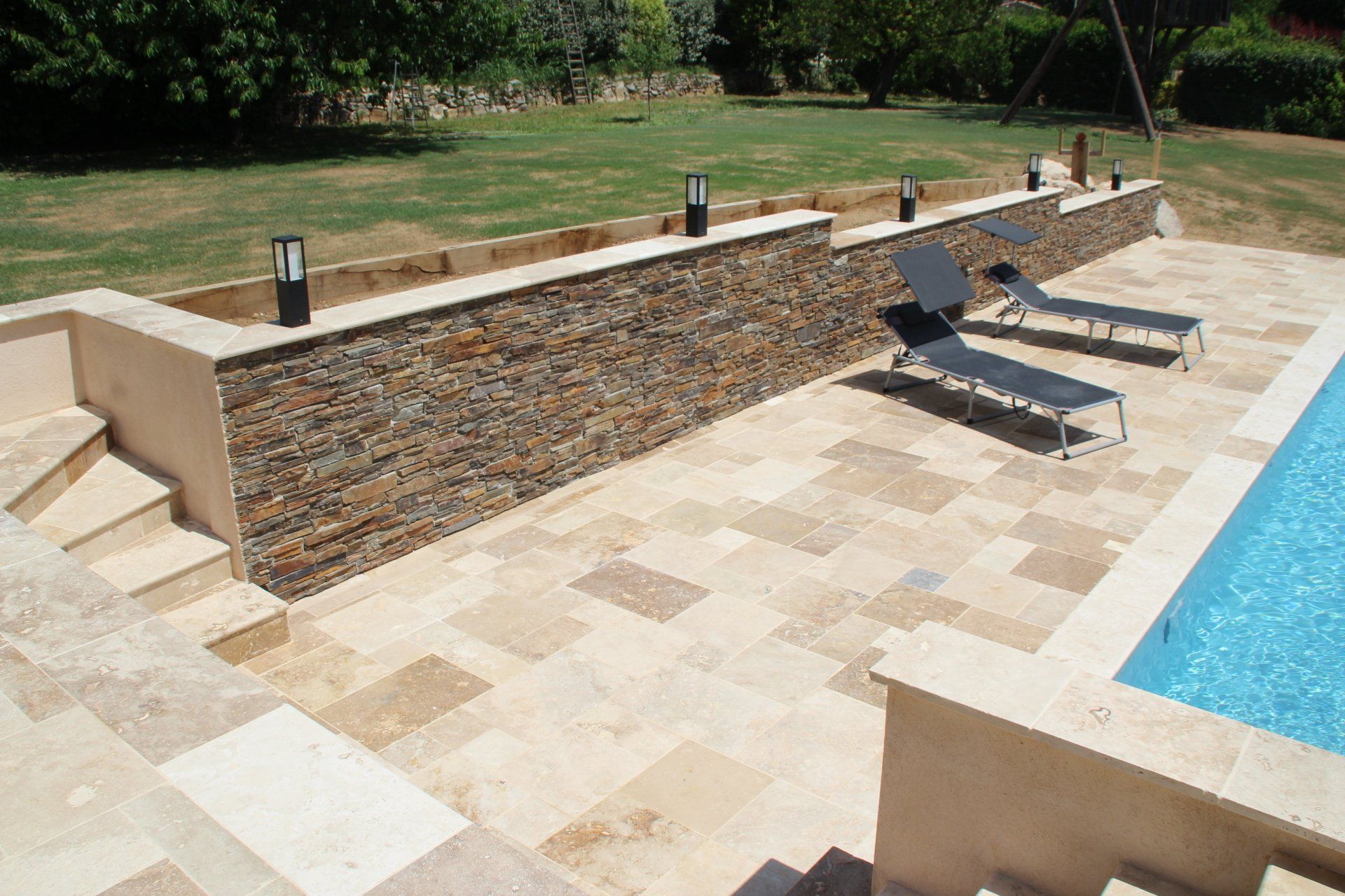 Photo d'un muret en pierres avec des lampes