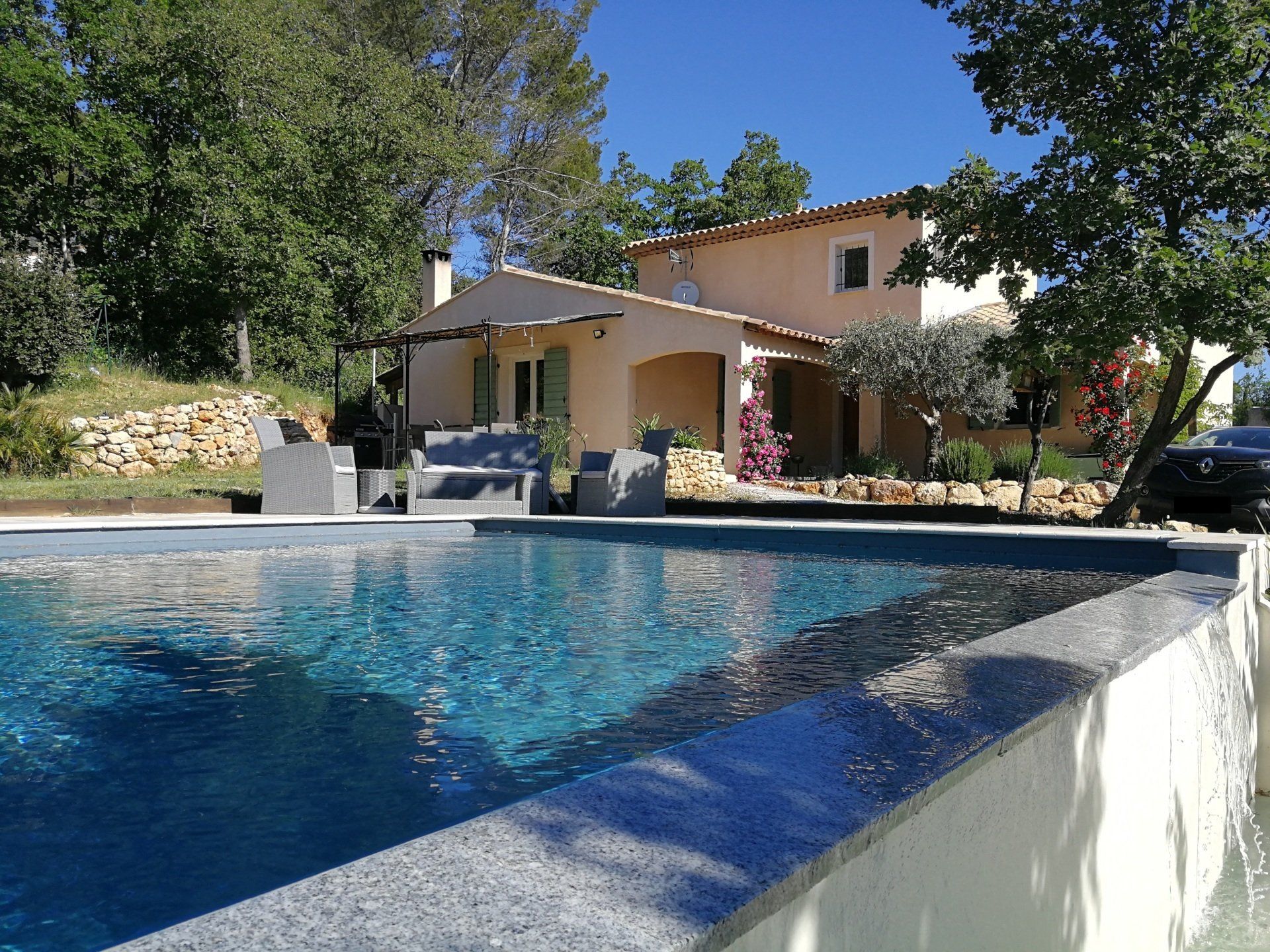 Piscine à débordement avec une maison en arrière-plan