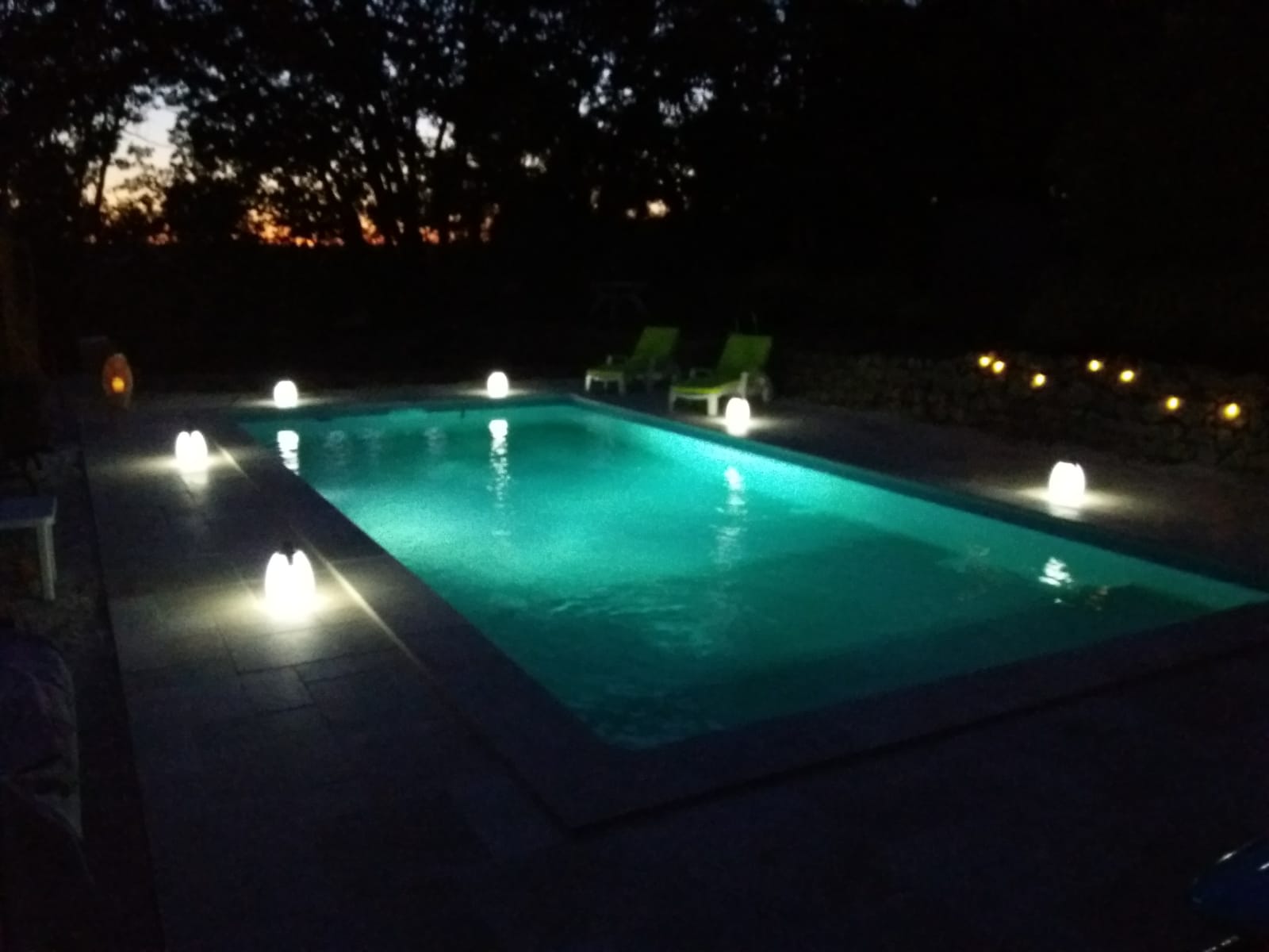 Photo de lanternes éclairées autour d'une piscine