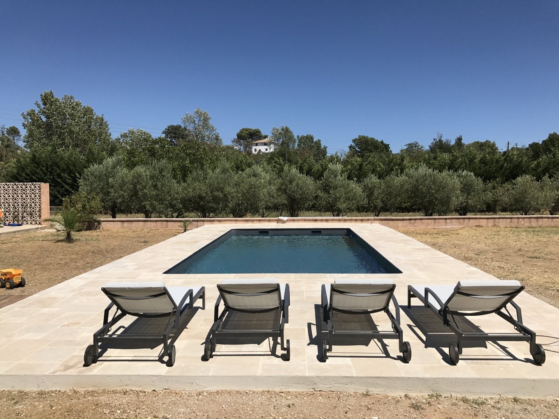 Photo d'une piscine prise derrière 4 transats
