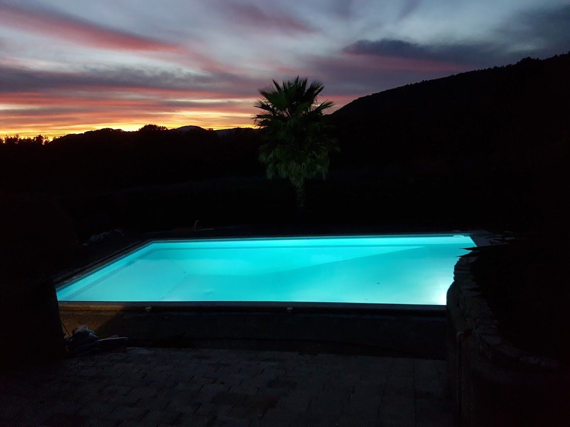 Photo d'une piscine de nuit avec éclairage intérieur