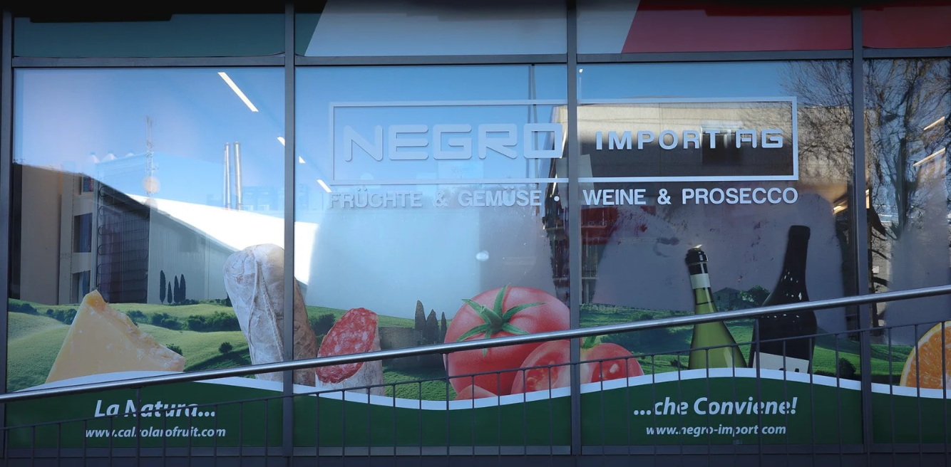 Ein Fenster mit einem Bild von Tomaten und Weinflaschen darauf.