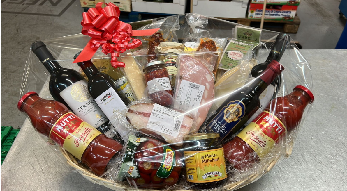 Ein Korb gefüllt mit Weinflaschen, Soßen und Fleisch.