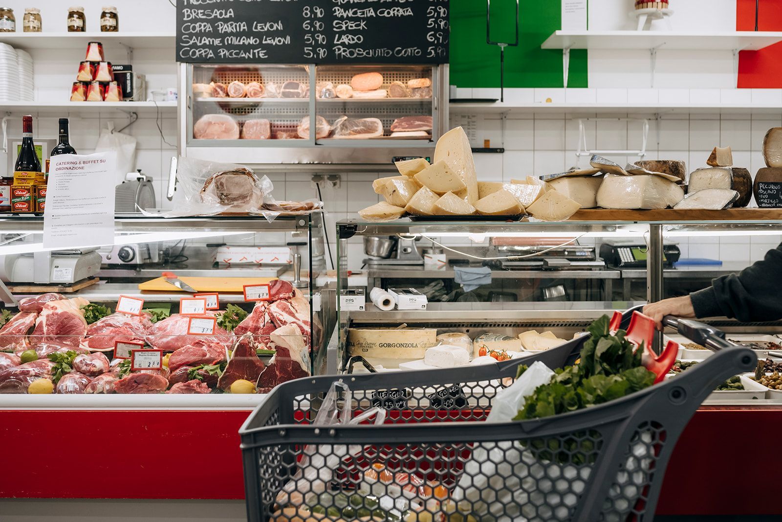 Eine Person schiebt einen Einkaufswagen voller Lebensmittel in einem Lebensmittelgeschäft.