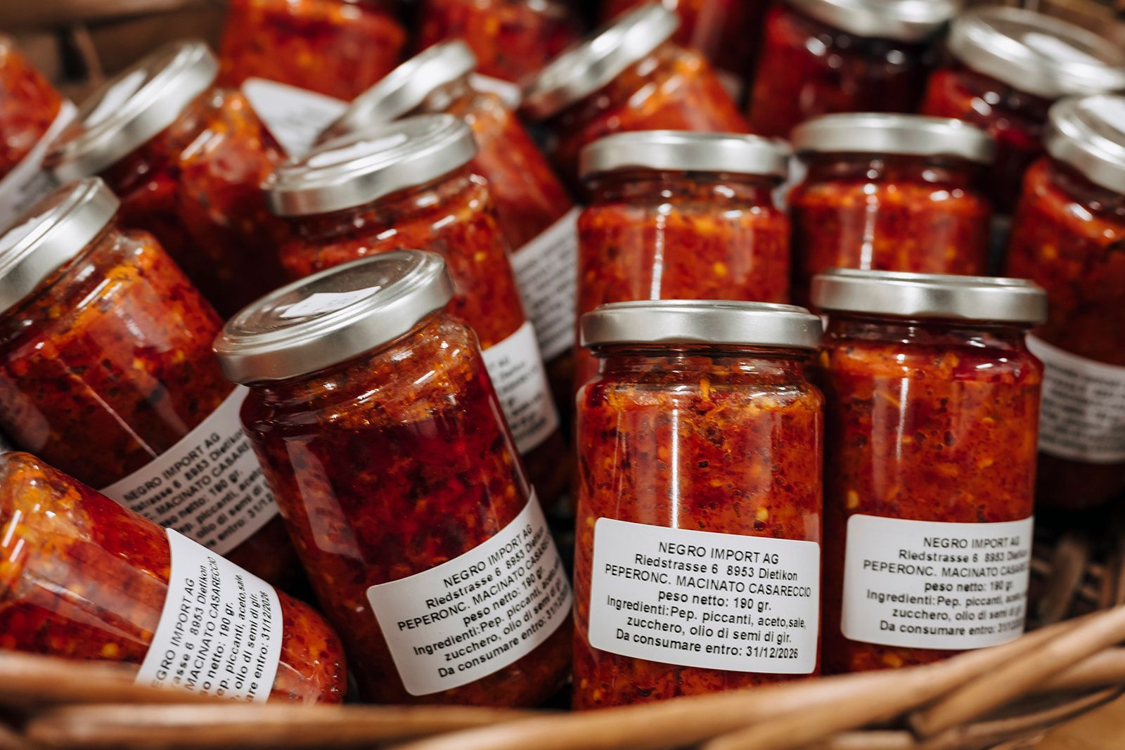 Ein Korb voller Gläser mit Tomatensoße.