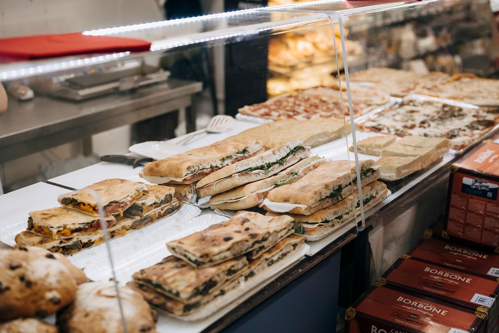 Eine mit Sandwiches und Pizzen gefüllte Vitrine in einer Bäckerei.