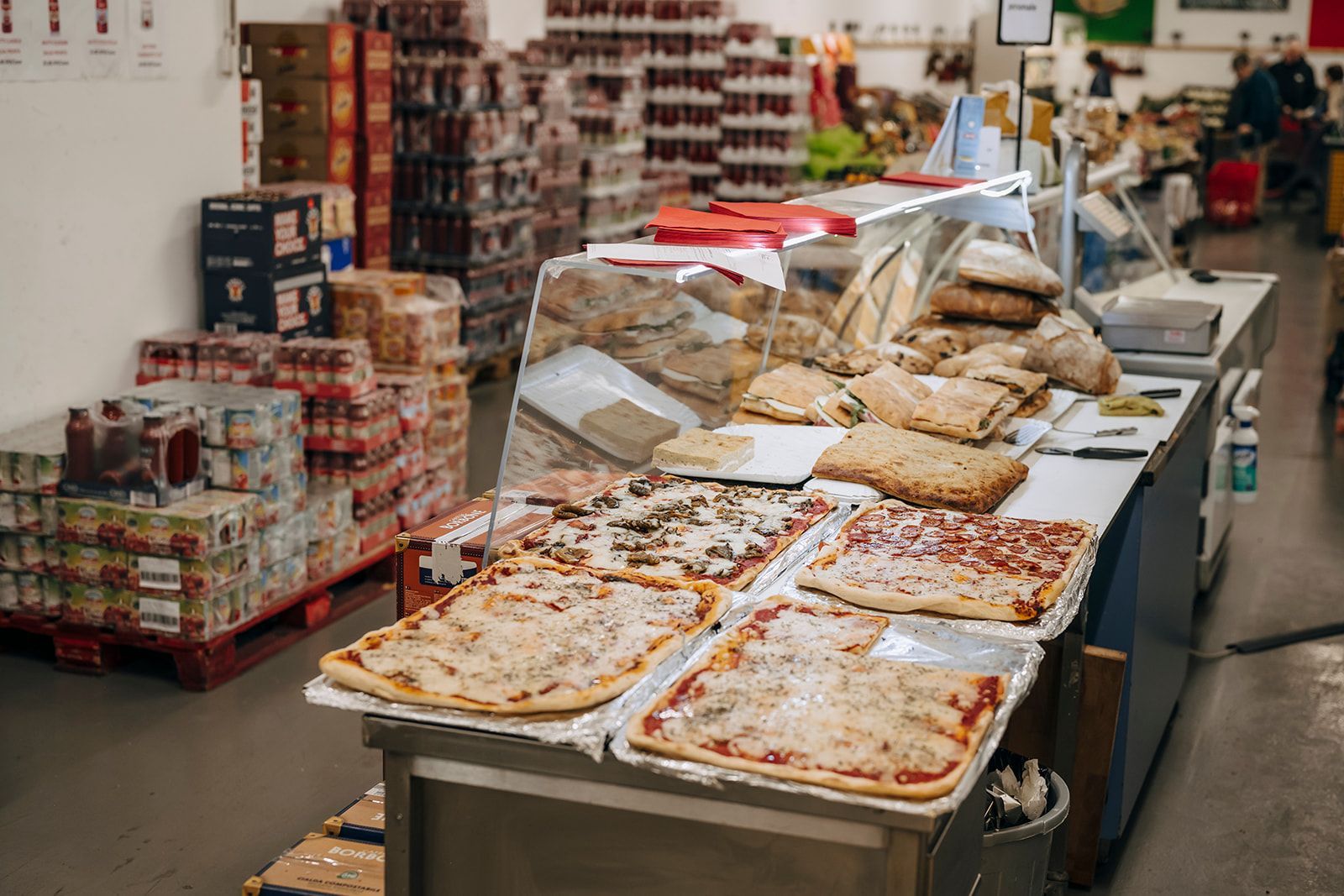 In einem Lagerhaus liegen viele Pizzen auf einem Tisch.