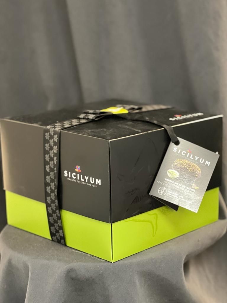 Auf einem Tisch steht eine schwarz-grüne Schachtel mit einem Etikett darauf.