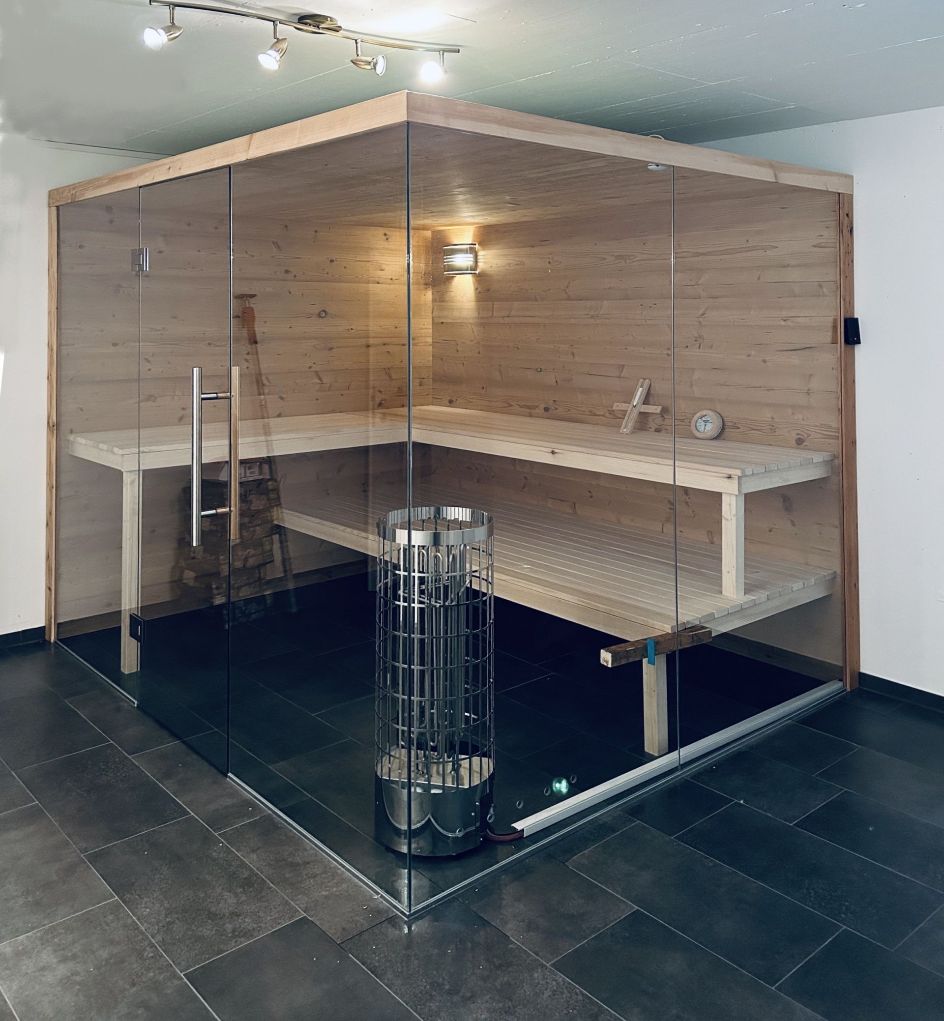 Zweistöckiges Haus mit Balkon, Terrasse und Garten. Grüner Rasen, Bäume und blauer Himmel.