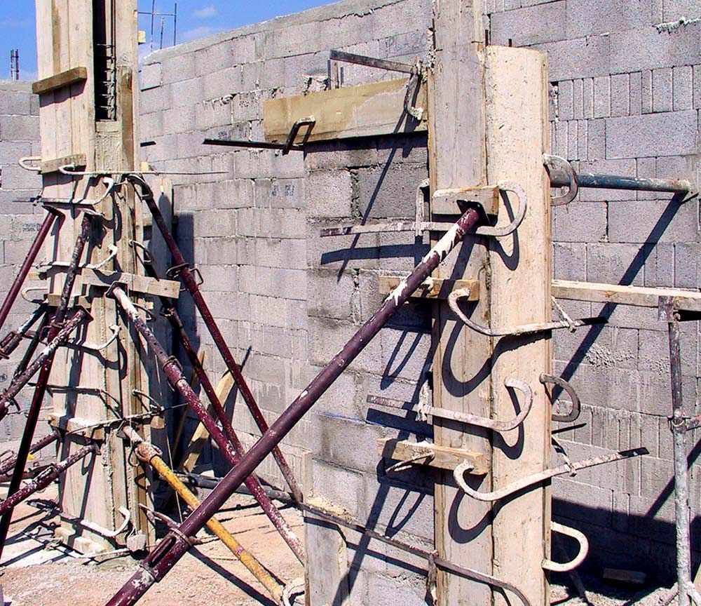 Étais et tuyaux de construction soutenant un mur en parpaings en construction