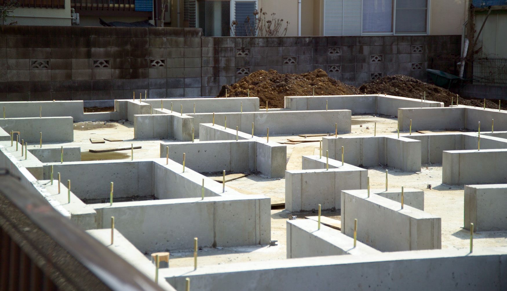 Murs de fondation en béton coulés pour une maison en construction sur un terrain résidentiel.